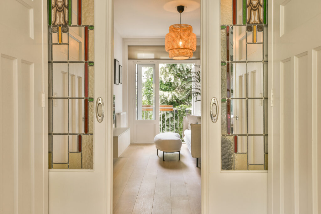 an entry door way leading to the living room and dining area with mirrors on either side by side, as seen from the front door